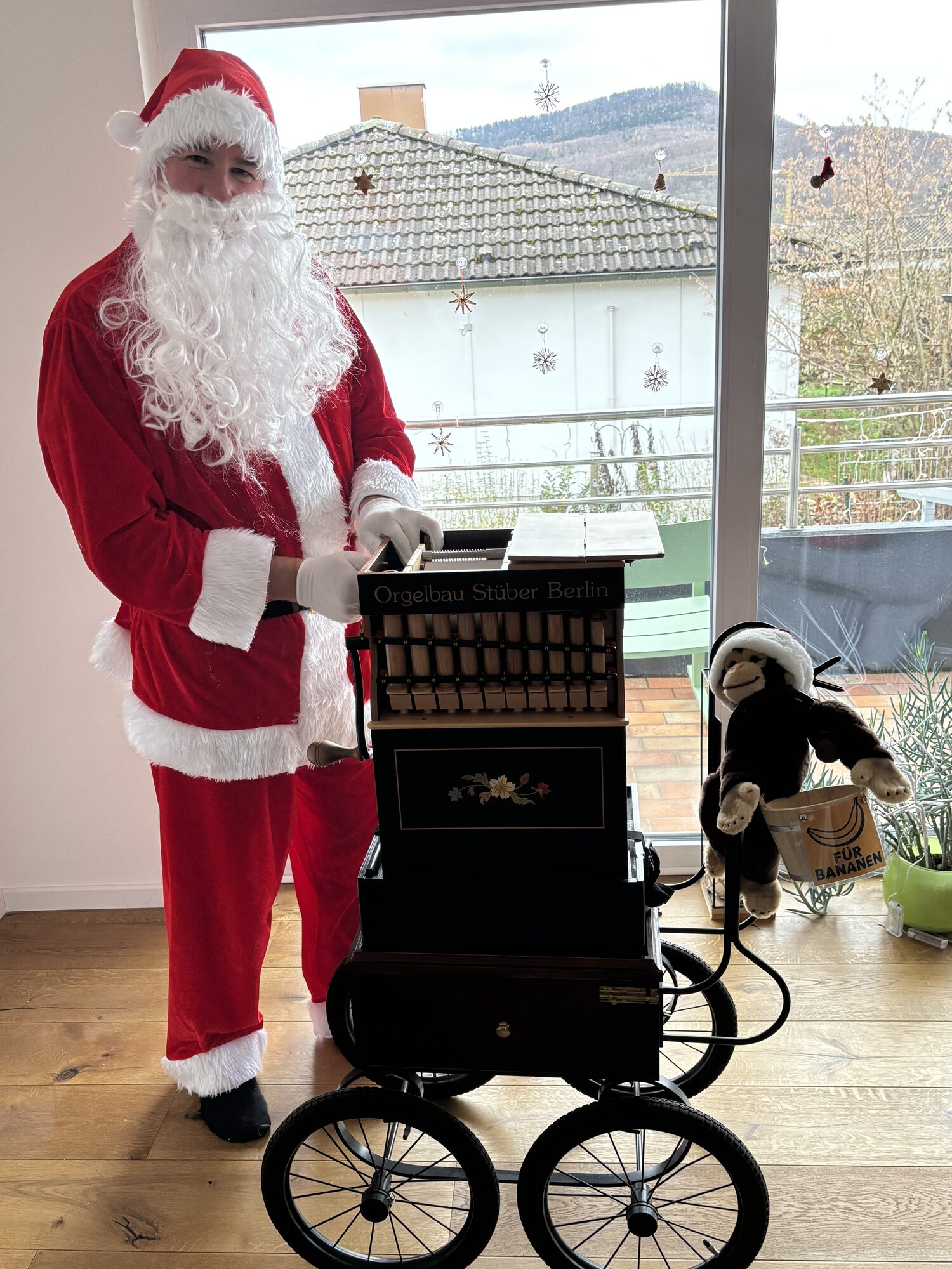 Leierkasten Joe als Weihnachtsmann verkleidet mit seiner Drehorgel – ideal für Weihnachtsmärkte und Adventsfeiern